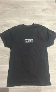 Original photo: a black T-shirt laid flat on a wooden floor.